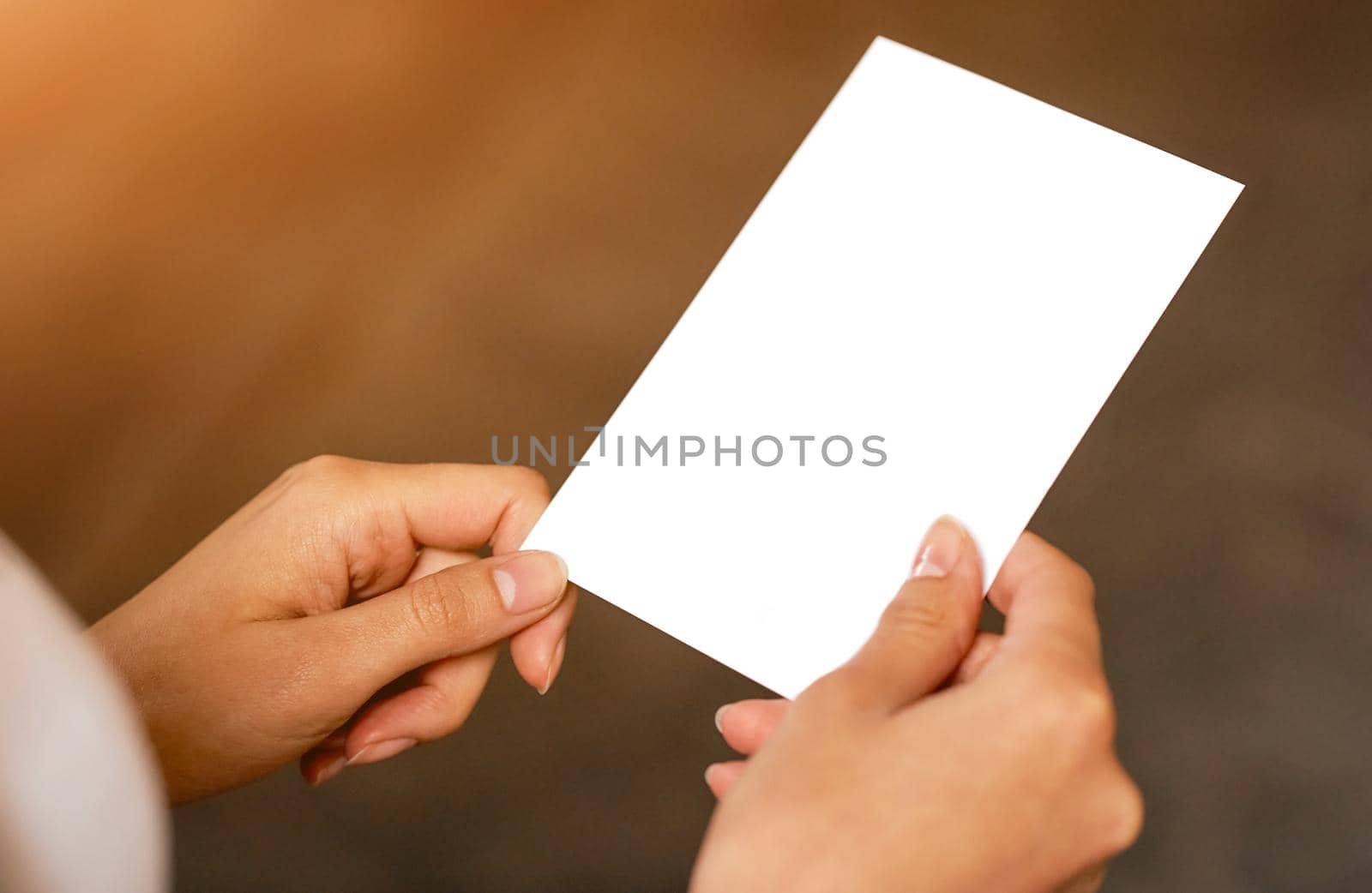 A person holding a white blank paper in her hand. High quality photo