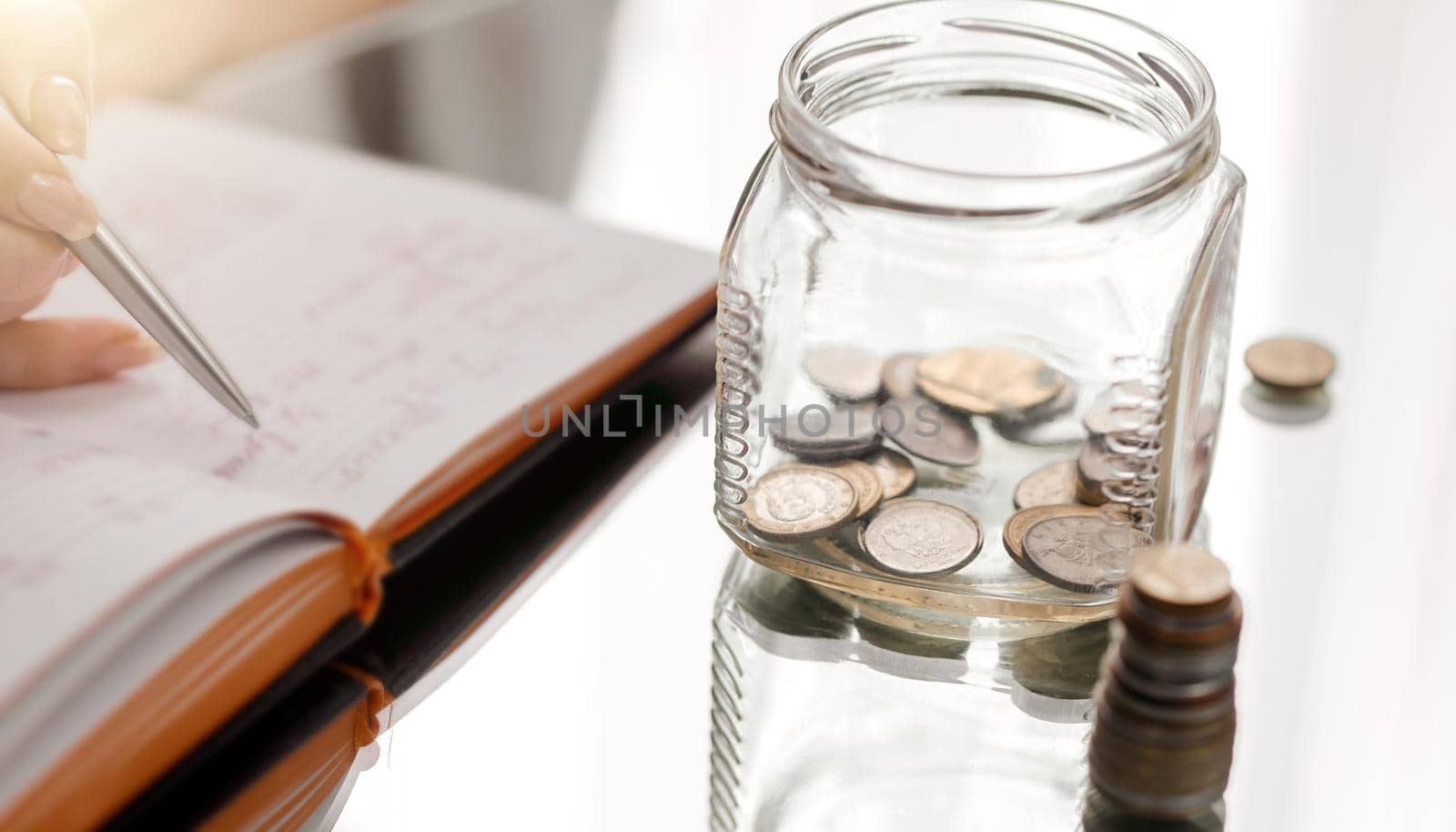 woman counting coins and writing on notepad mirror table. High quality photo