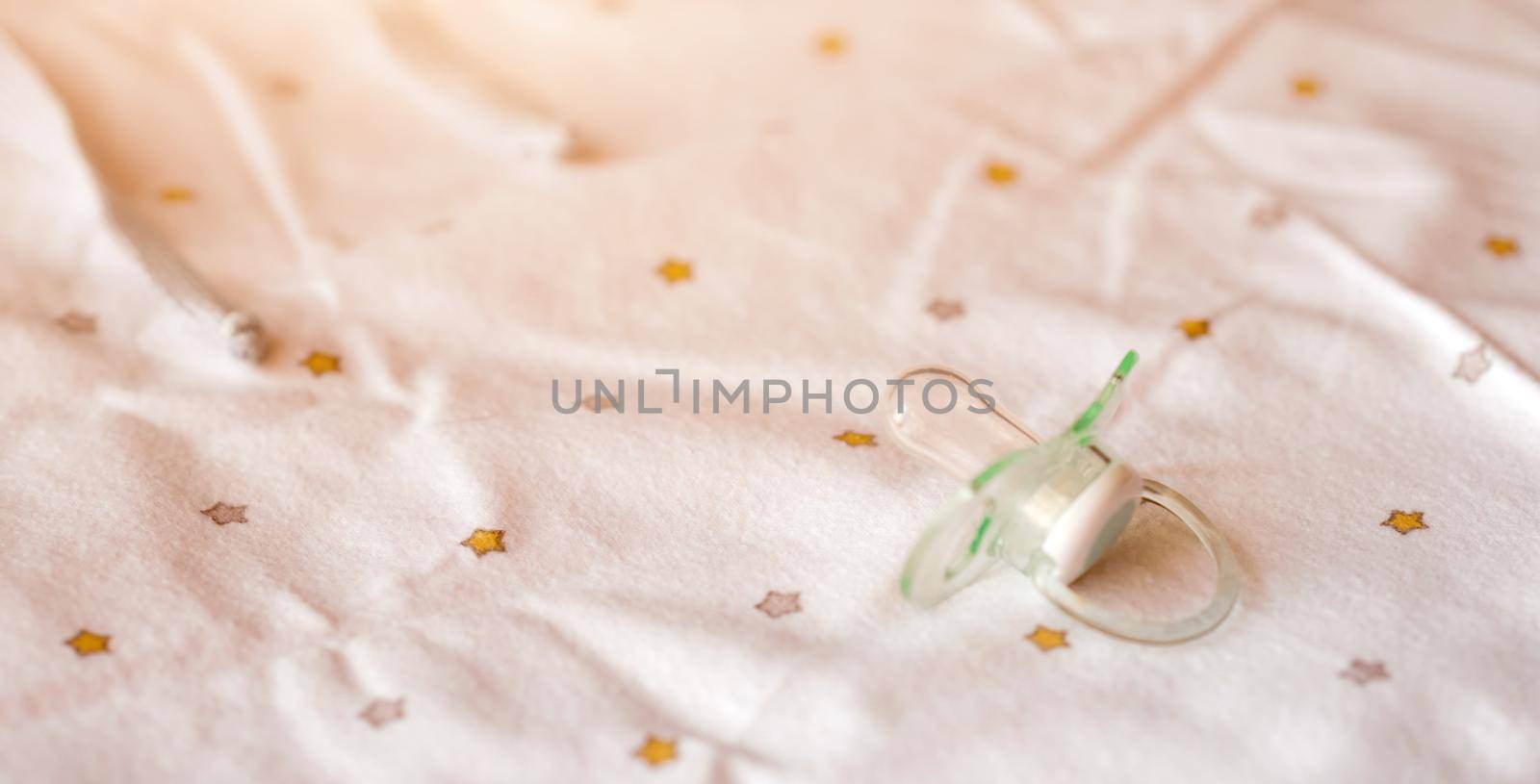 Bright silicone babys dummy on white blanket background. High quality photo