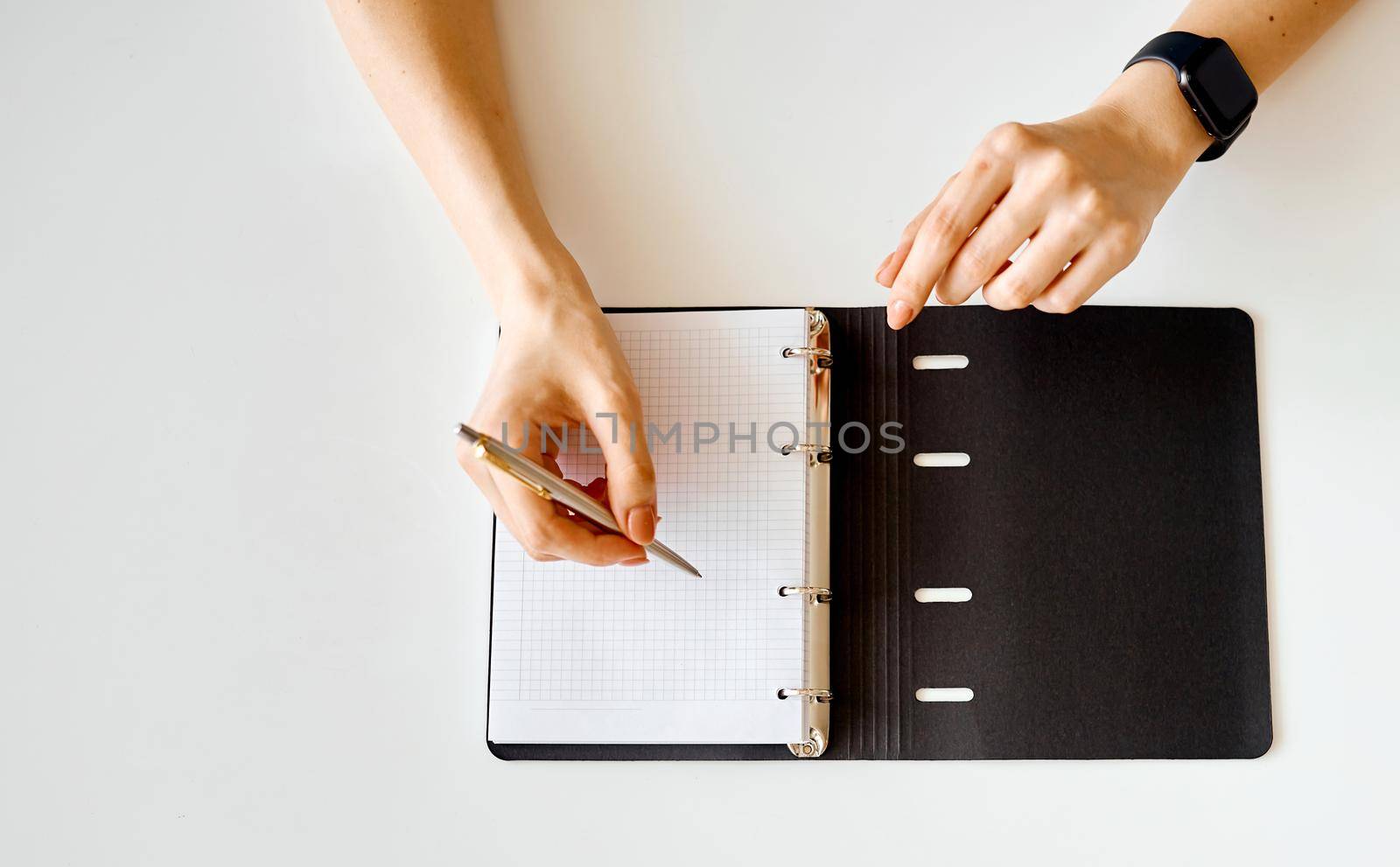 woman writes something in a notebook with a black cover . High quality photo