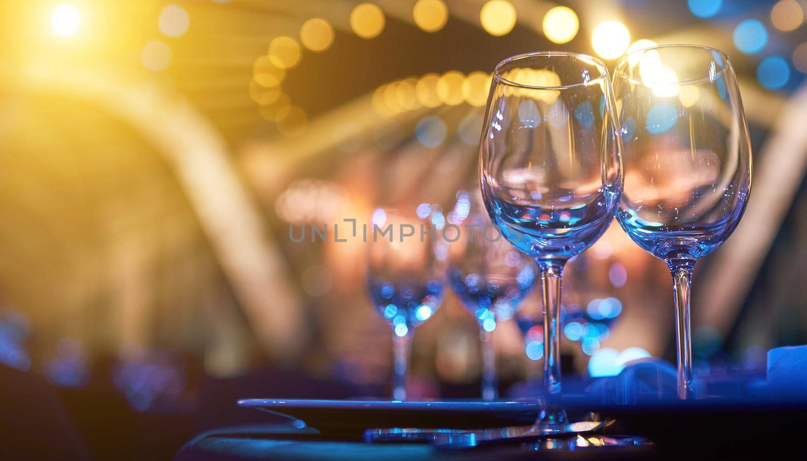 A glass of wine on table with colorful backlight by AntonIlchanka