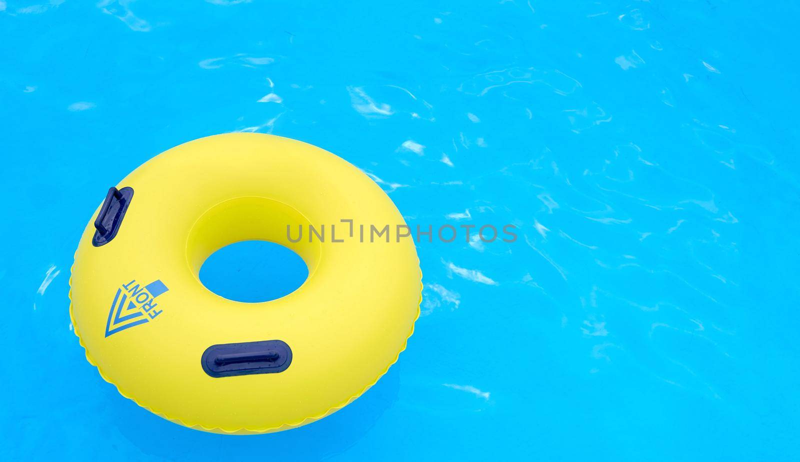 yellow lifeline with the inscription front and arrow pointing to the bottom left corner on the water in the pool . High quality photo