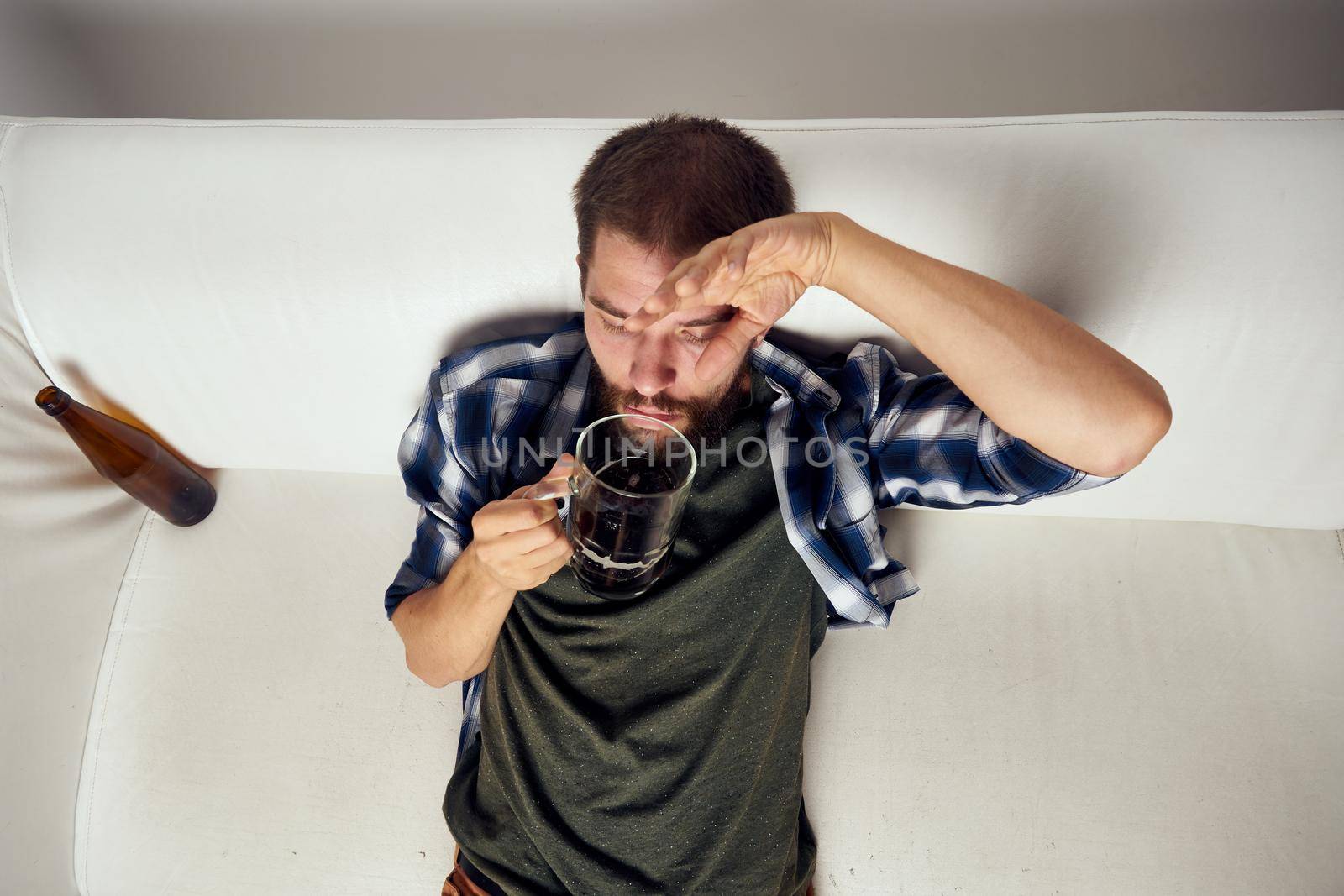 drunk man drinking beer alcohol emotion light background. High quality photo