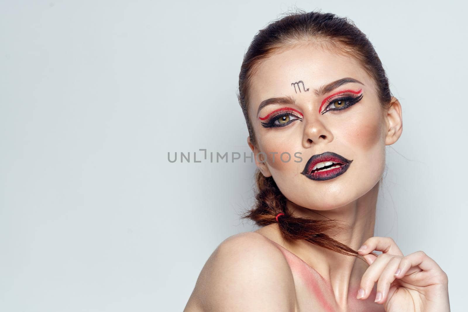 beautiful woman posing scorpio sign on forehead cosmetics light background by Vichizh