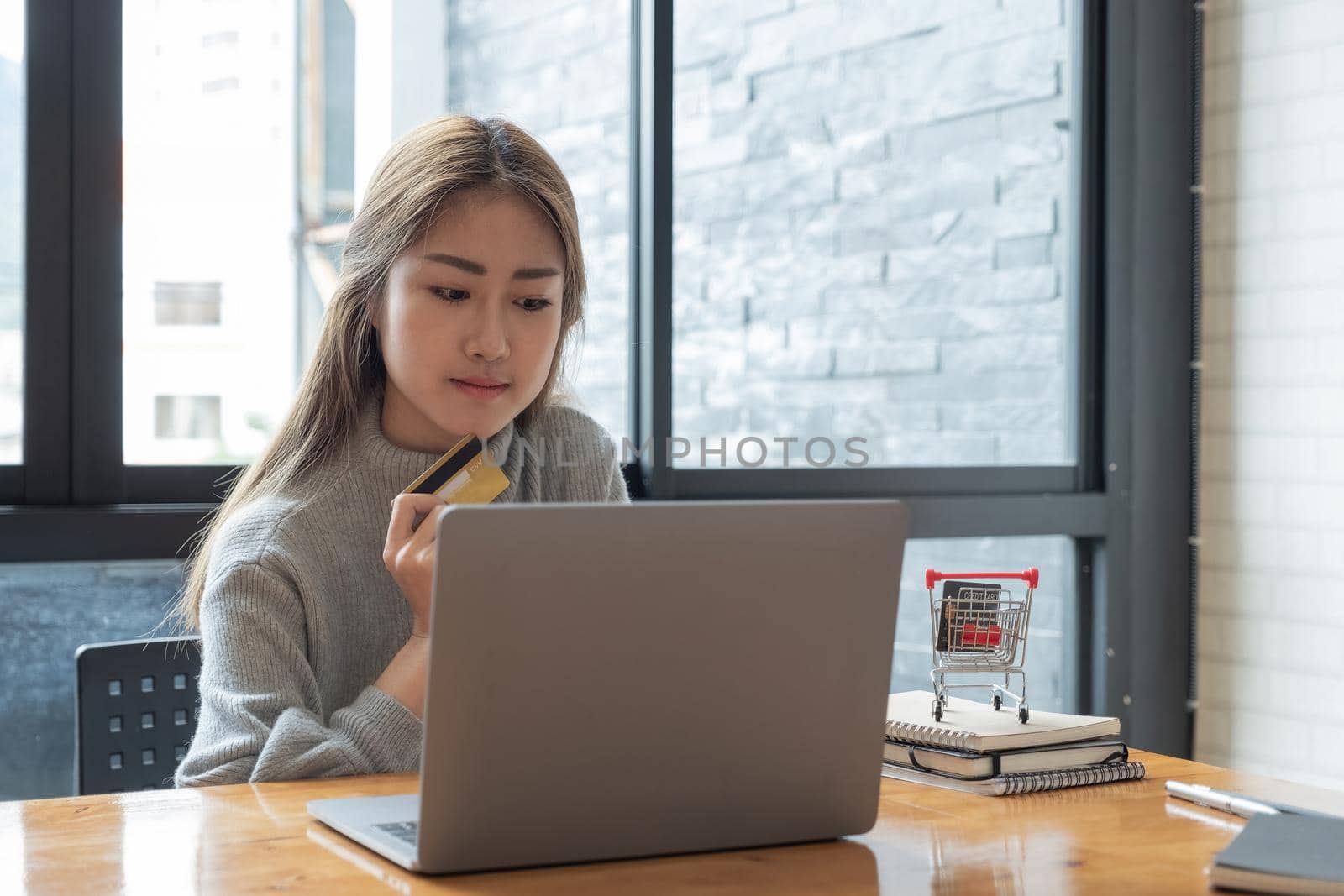 Close up young asian woman holding credit card and using tablet computer. Businesswoman working at home. Online shopping, e-commerce, internet banking, spending money, working from home concept.