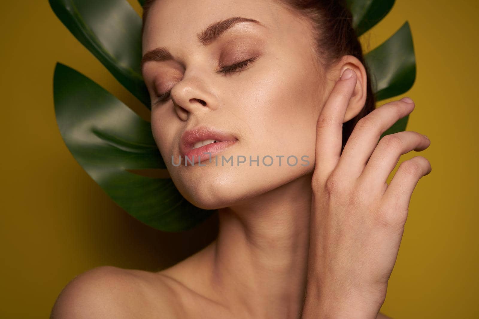 pretty woman clean skin palm leaf cosmetics studio model. High quality photo