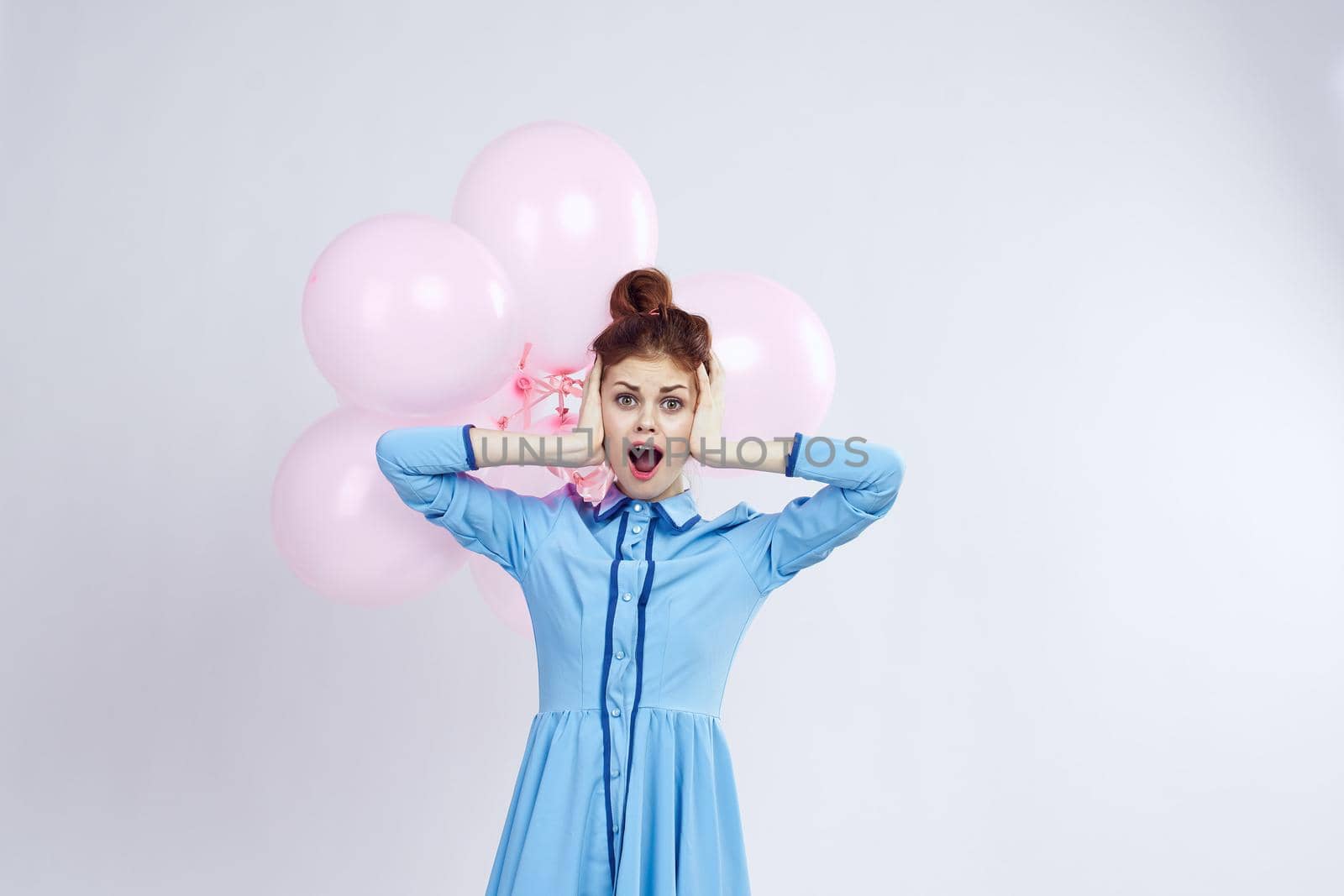 cheerful woman in a blue dress pink balloons holiday birthday. High quality photo