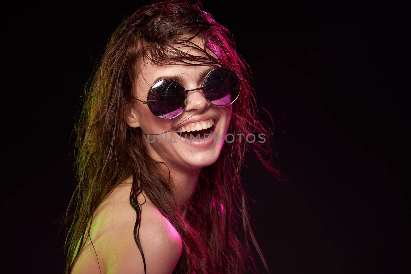 portrait of a woman wearing sunglasses posing luxury dark background. High quality photo