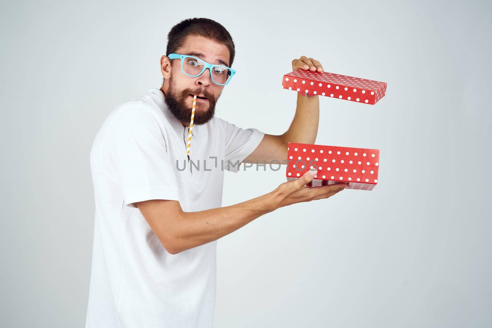 bearded man in a white shirt holding a holiday gift. High quality photo