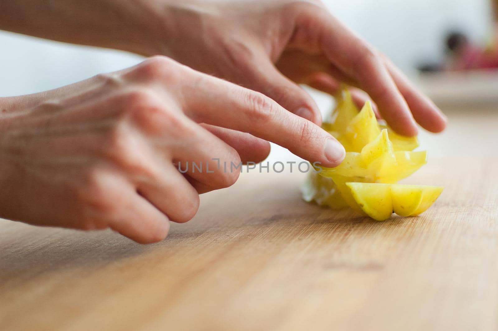 Female hands are holding slice of exotic ripe starfruit or averrhoa carambola. Healthy food, fresh organic star apple fruit.