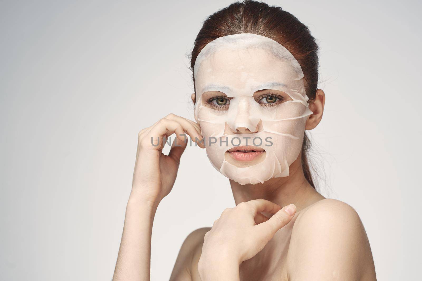 emotional woman cosmetic face mask close-up light background by Vichizh