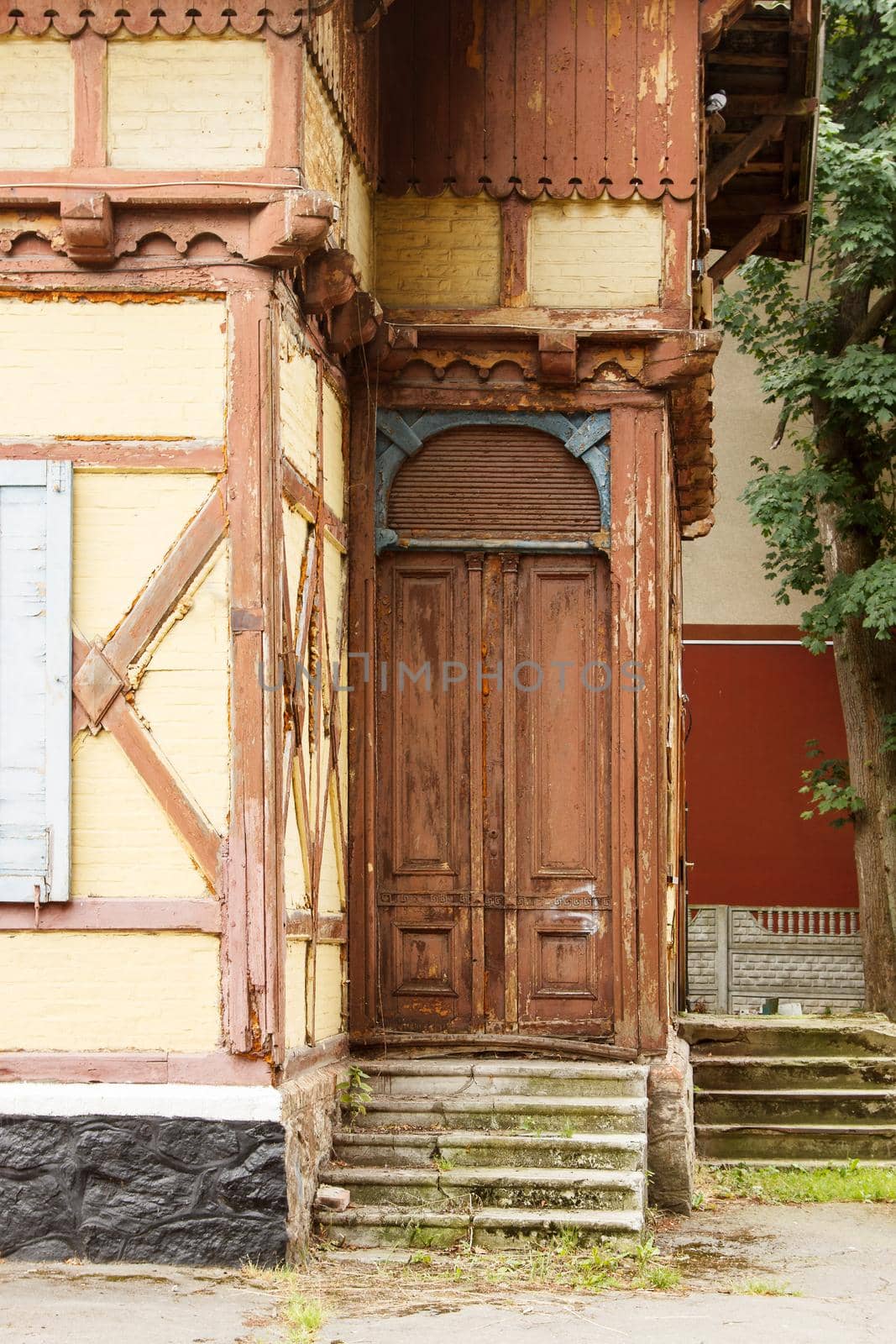 entrance door of old abandoned house on city street on summer day