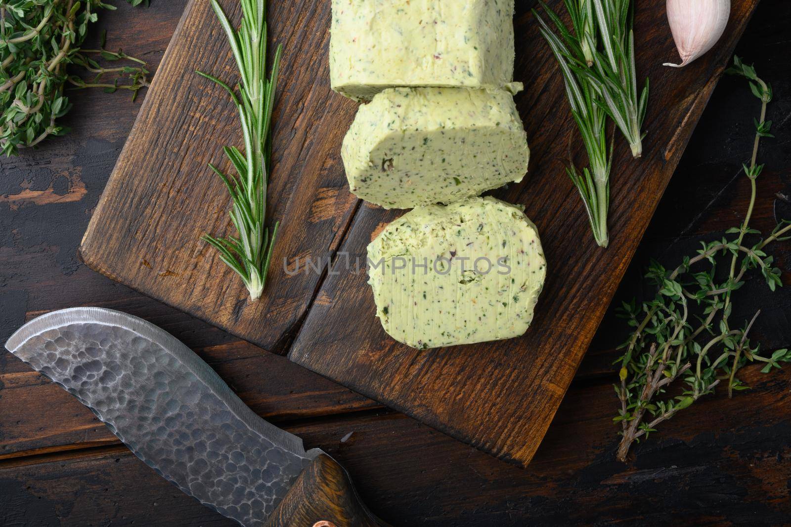Homemade Butter with thyme and rosemary and lemon zest set, on old dark wooden table background