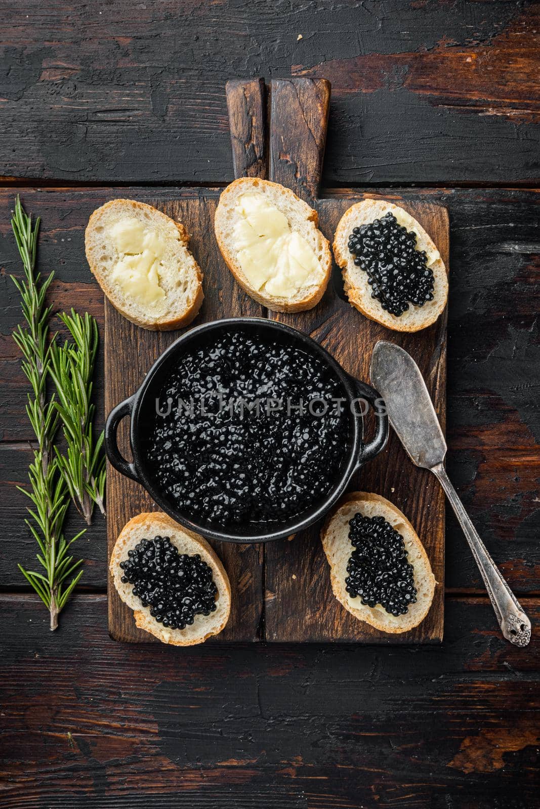 Sandwiche with black caviar, on old dark wooden table background, top view flat lay