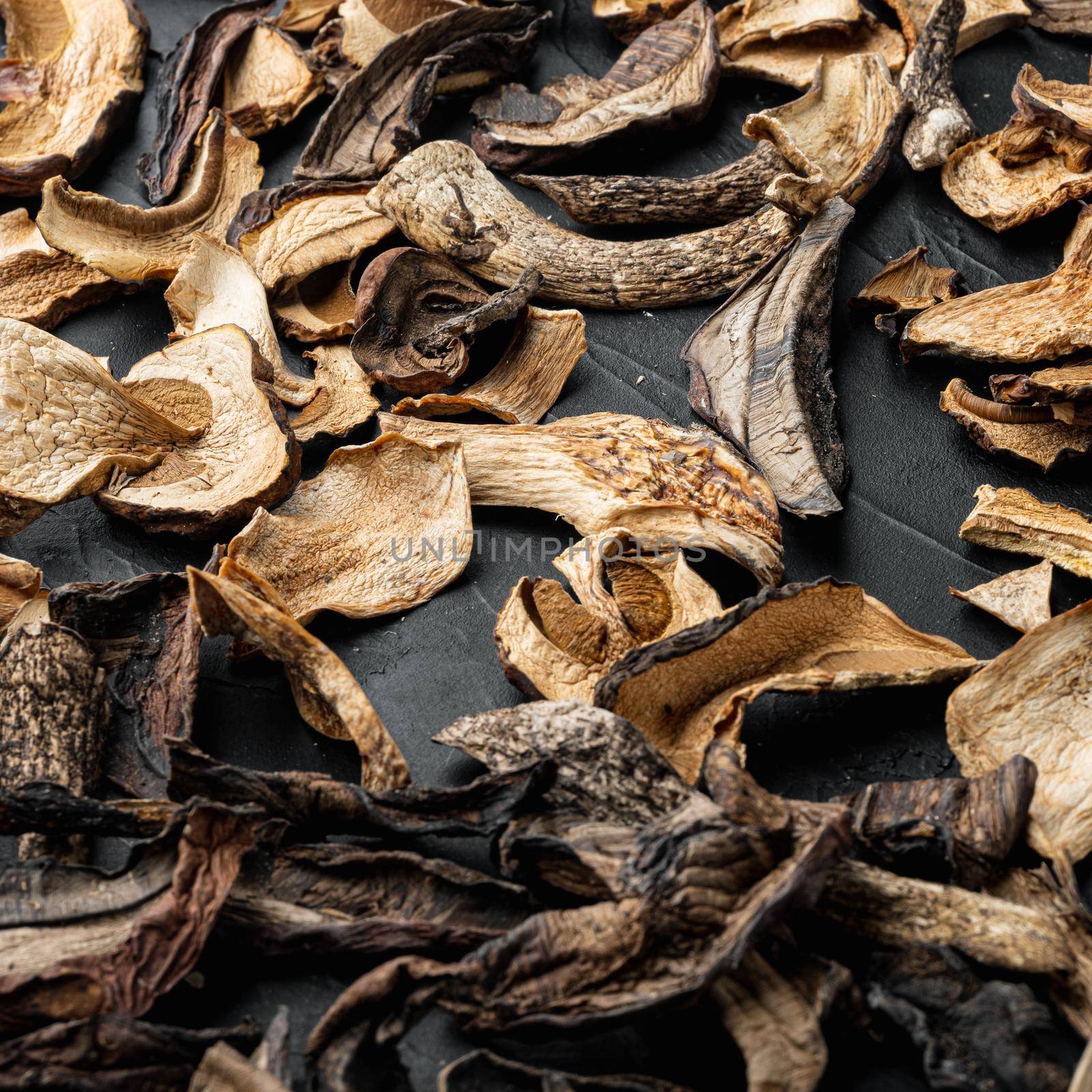 Mix of chopped wild dried mushrooms, on black background by Ilianesolenyi