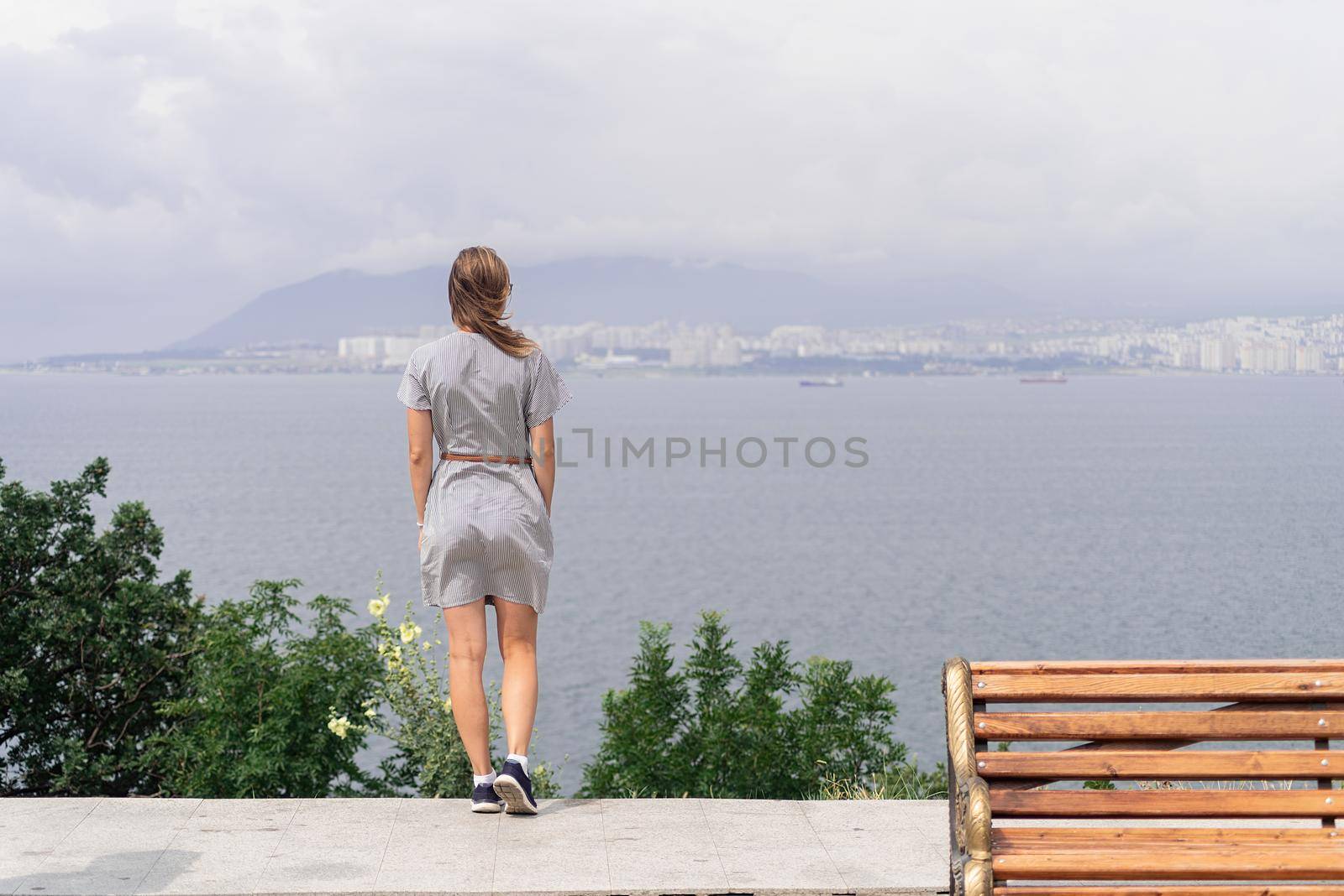 Back view of young woman looking at the cityscape by Desperada