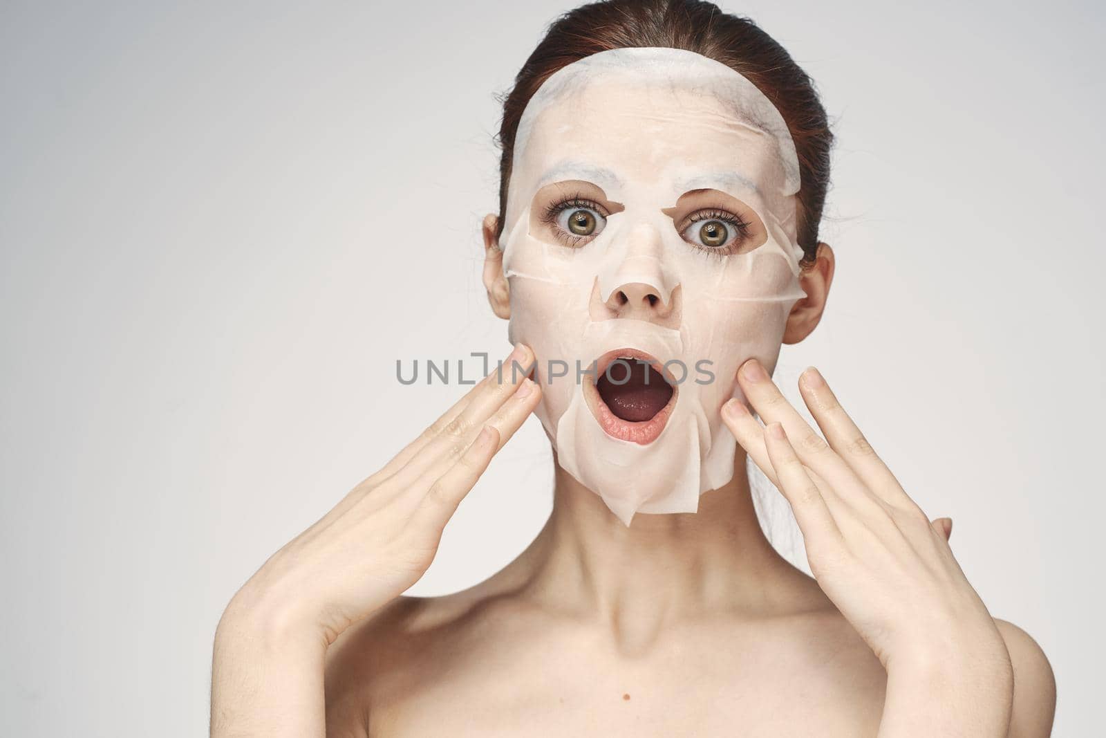 emotional woman cosmetic face mask close-up light background. High quality photo