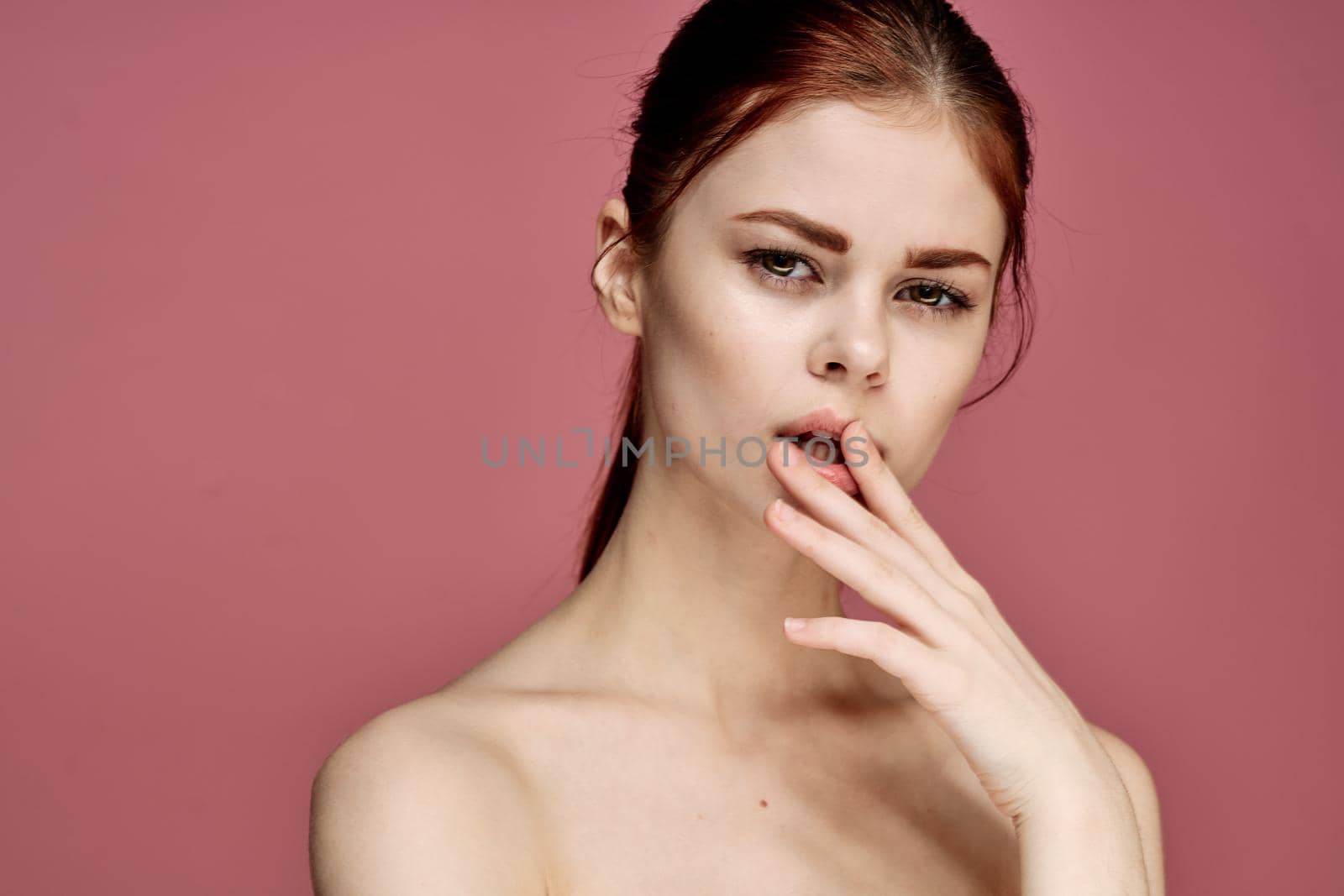 woman with bare shoulders charm cosmetics pink background posing. High quality photo