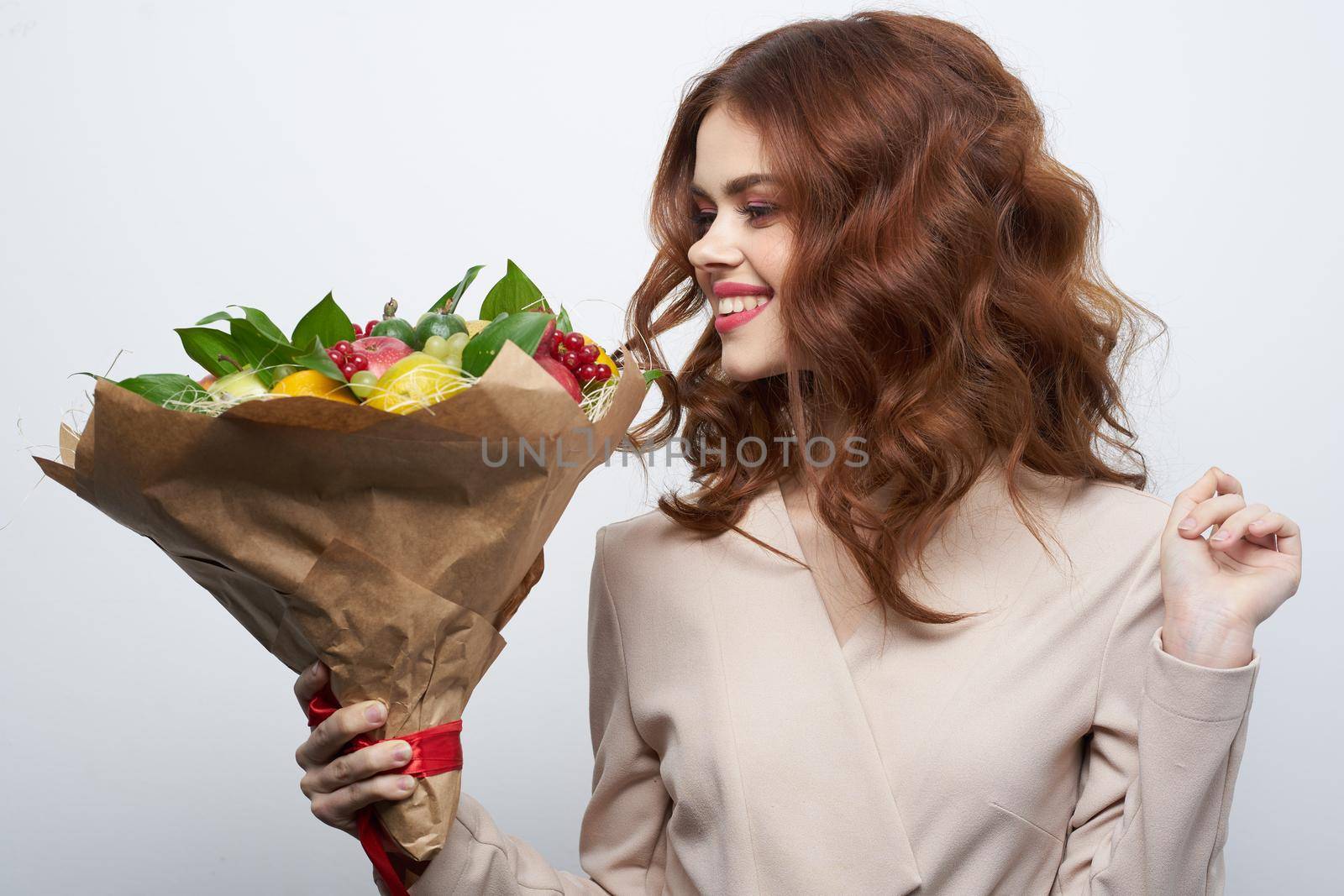 cheerful woman smile posing fresh fruits bouquet emotions light background. High quality photo