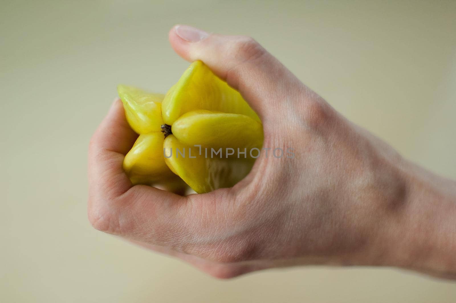 Female hands are holding exotic ripe starfruit or averrhoa carambola. Healthy food, fresh organic star apple fruit