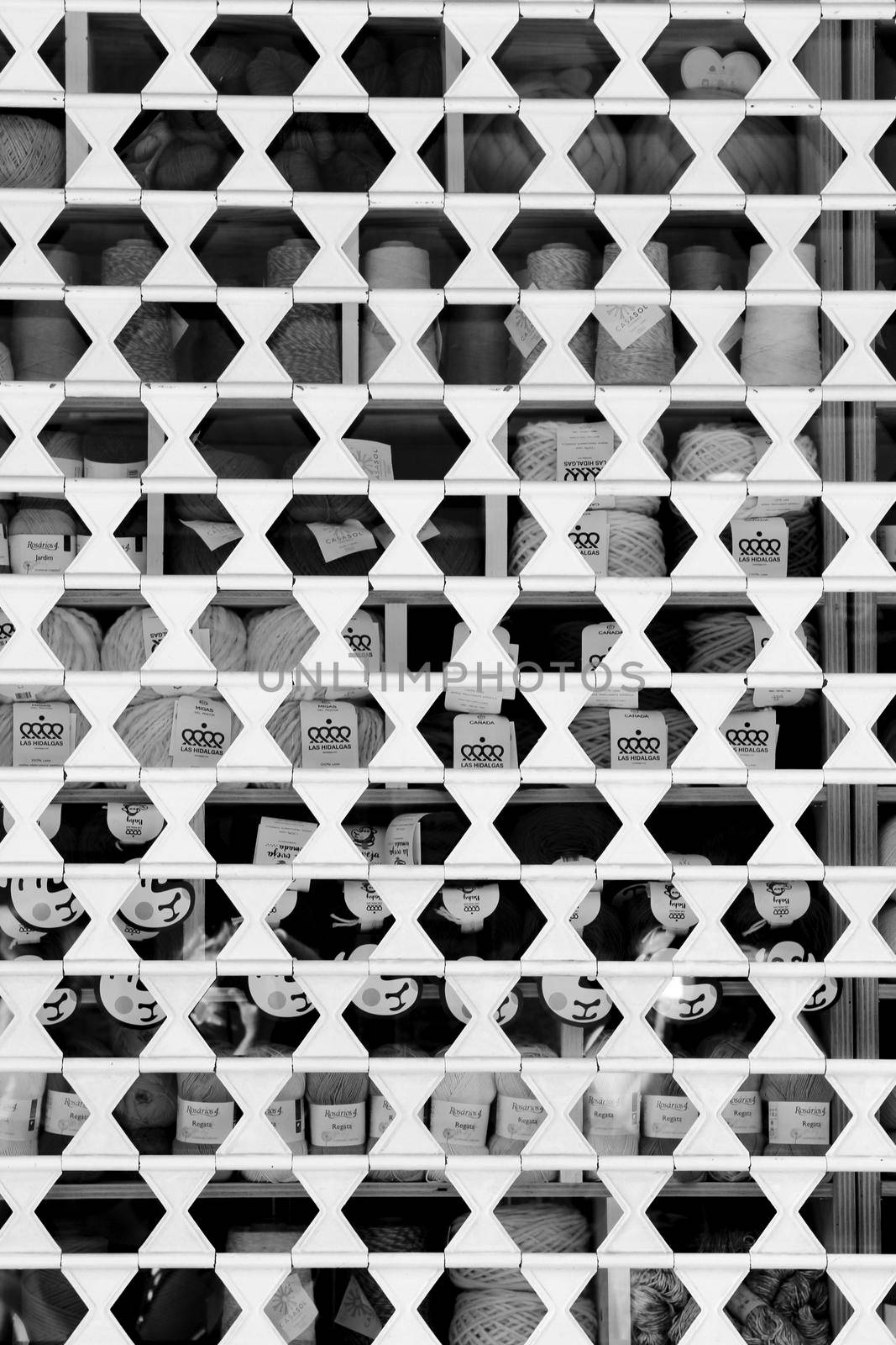 Alicante, Spain- October 9, 2021: Closed shop showcase blind pattern. Monochrome picture.