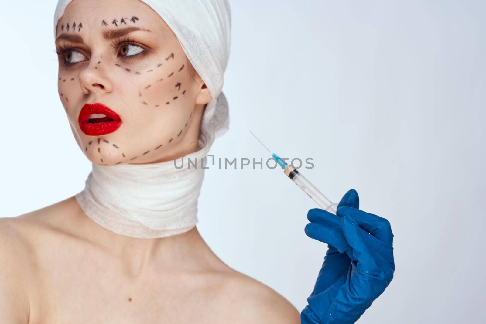 portrait of a woman in blue gloves syringe in hands contour on the face lifting studio lifestyle. High quality photo