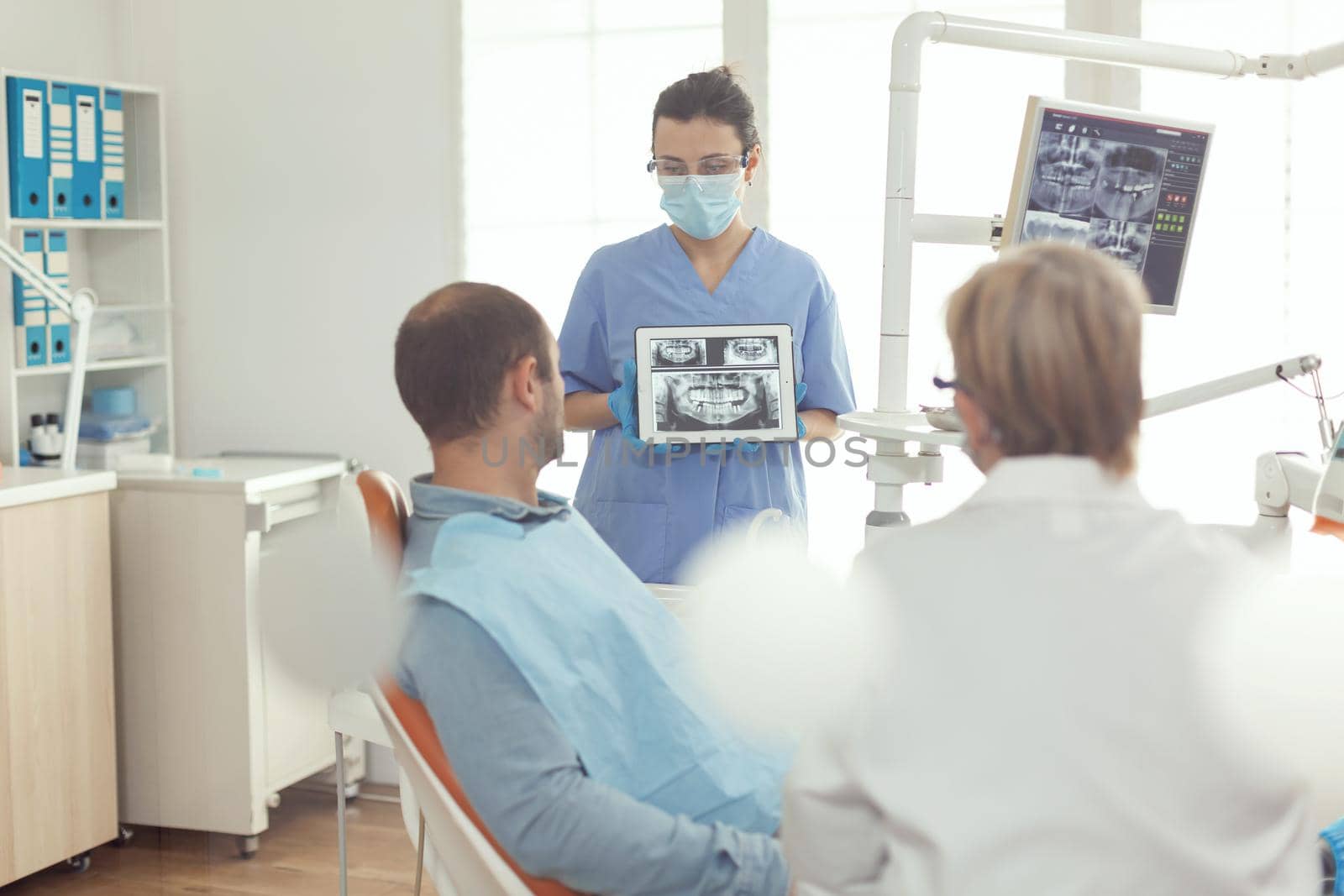 Orthodontist nurse holding digital tablet with tooth radiography on screen by DCStudio