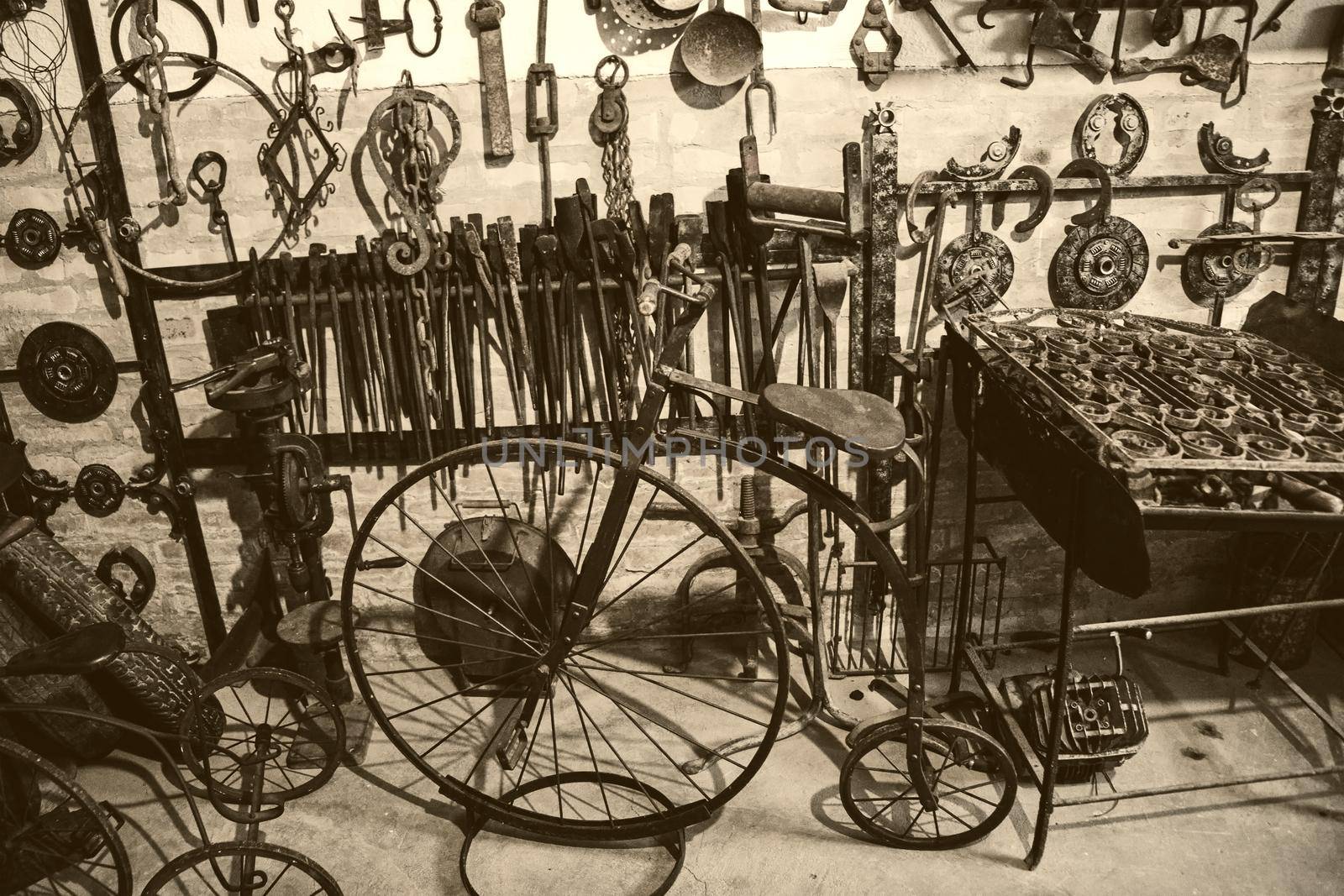 old bicycle and iron tools hanging on the wall - hardware workshop