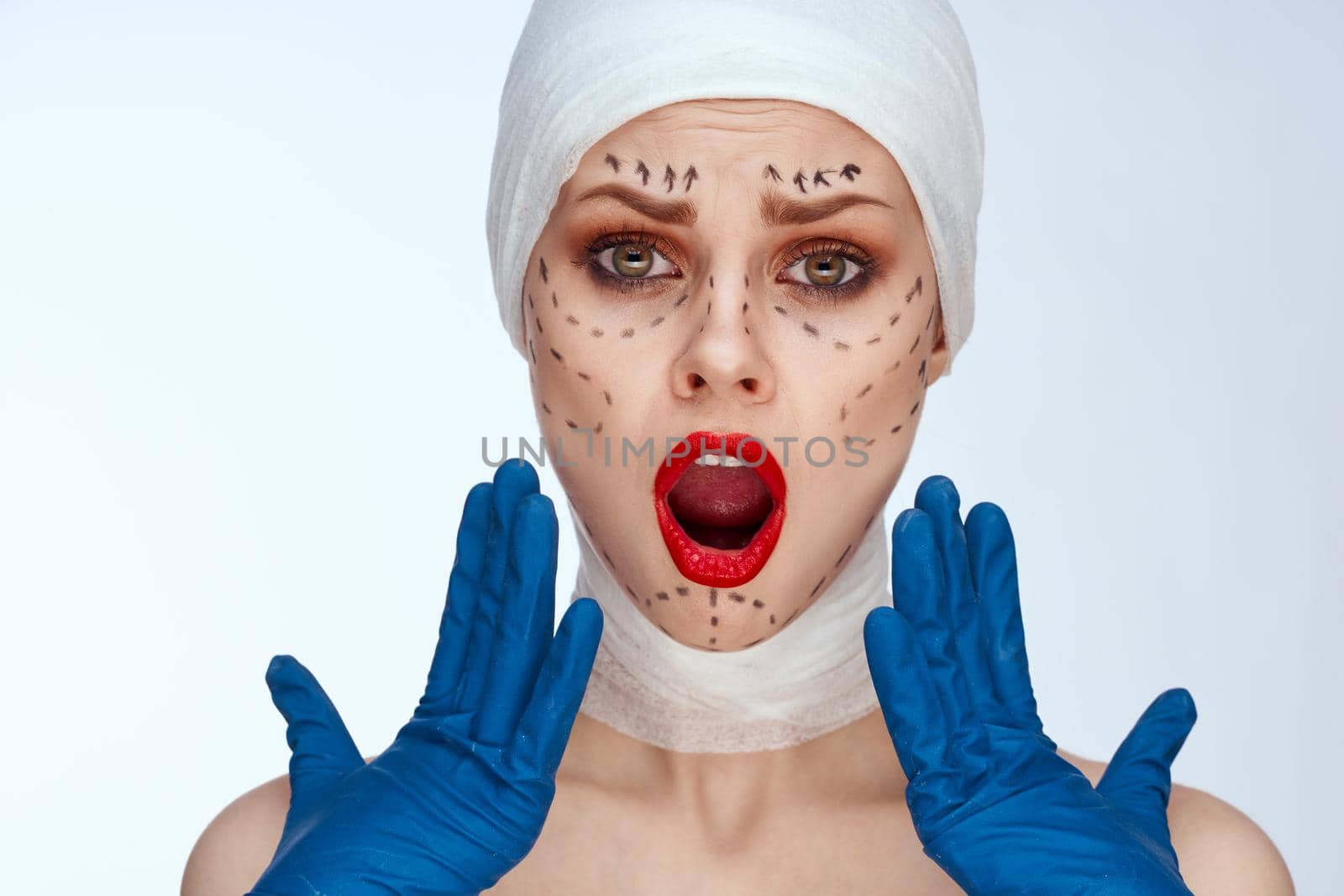 woman in blue gloves syringe in hands contour on the face lifting light background by Vichizh