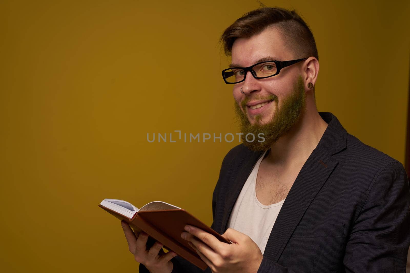 bearded man in a black jacket with a book in his hands education. High quality photo