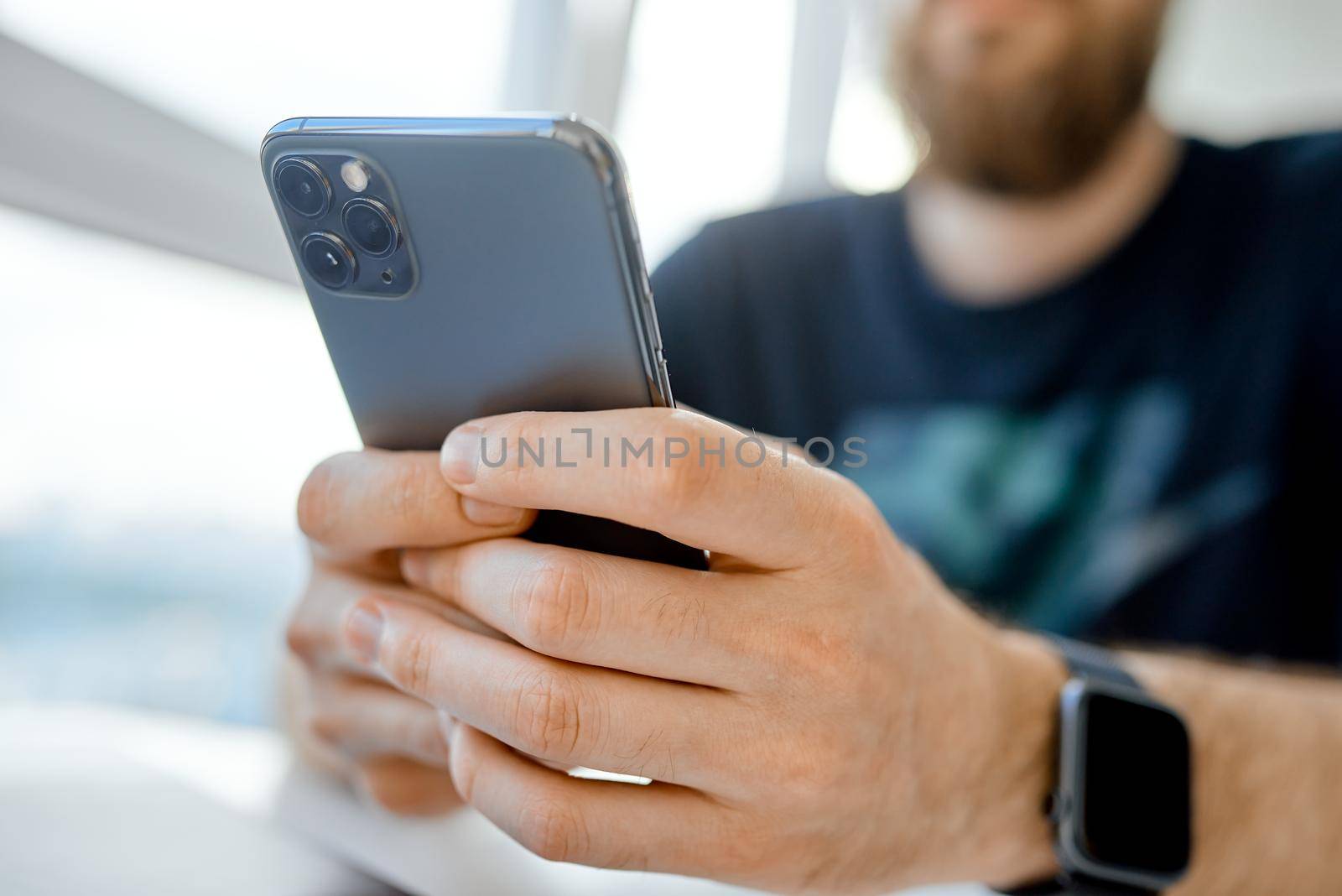 man texting with both hands on phone closeup . High quality photo