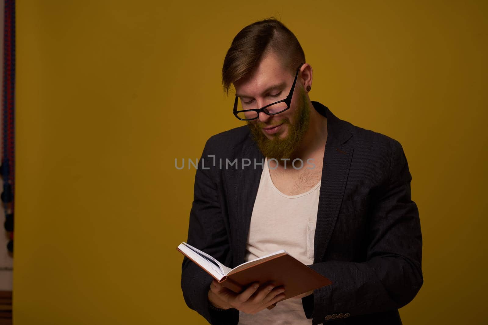 bearded man in a black jacket with a book in his hands education. High quality photo