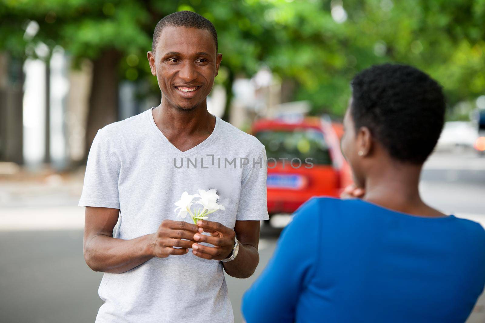 Young people standing face to face are looking at each other smiling.