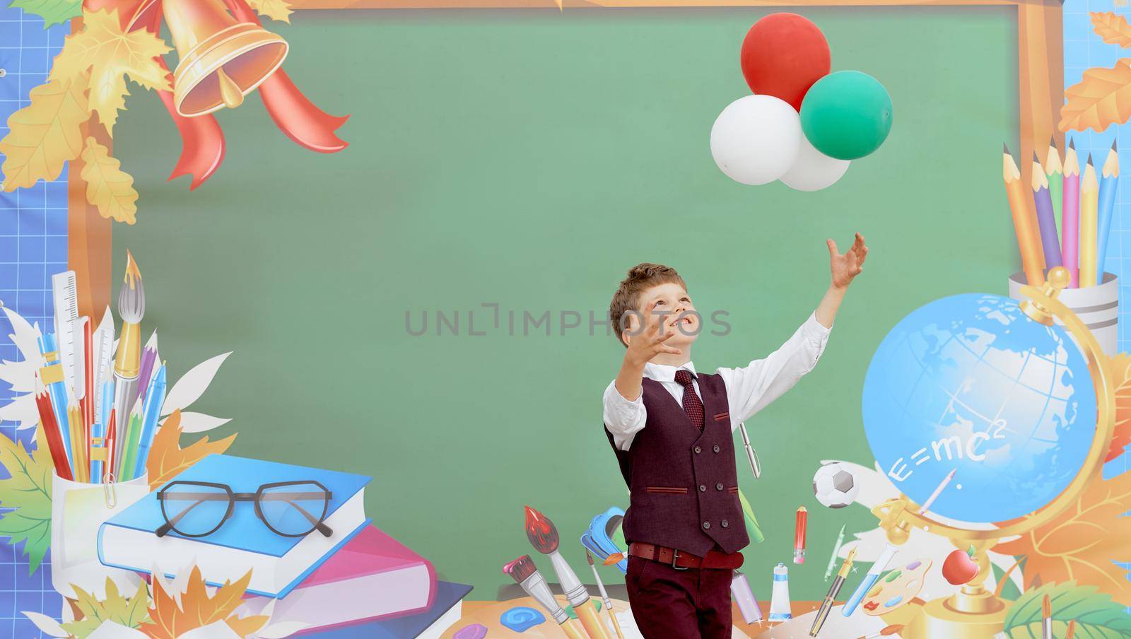 A boy in a suit plays with balls. First day of school. . High quality photo