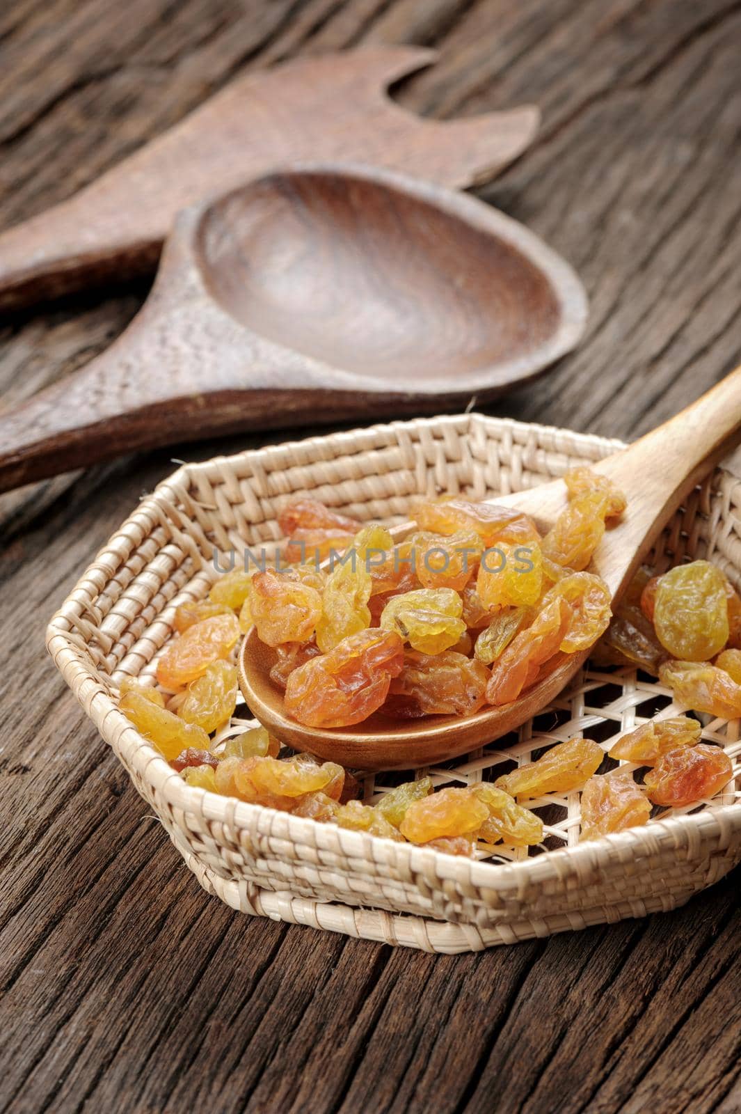 closeup heap of delicious raisins on wooden spoon