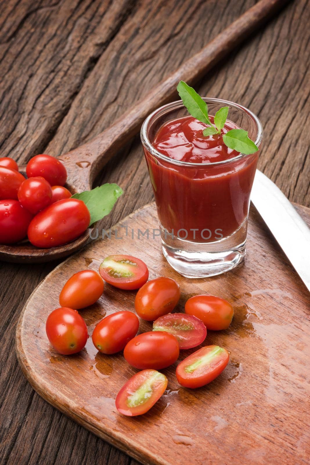 closeup a glass of ketchup and tomatoes