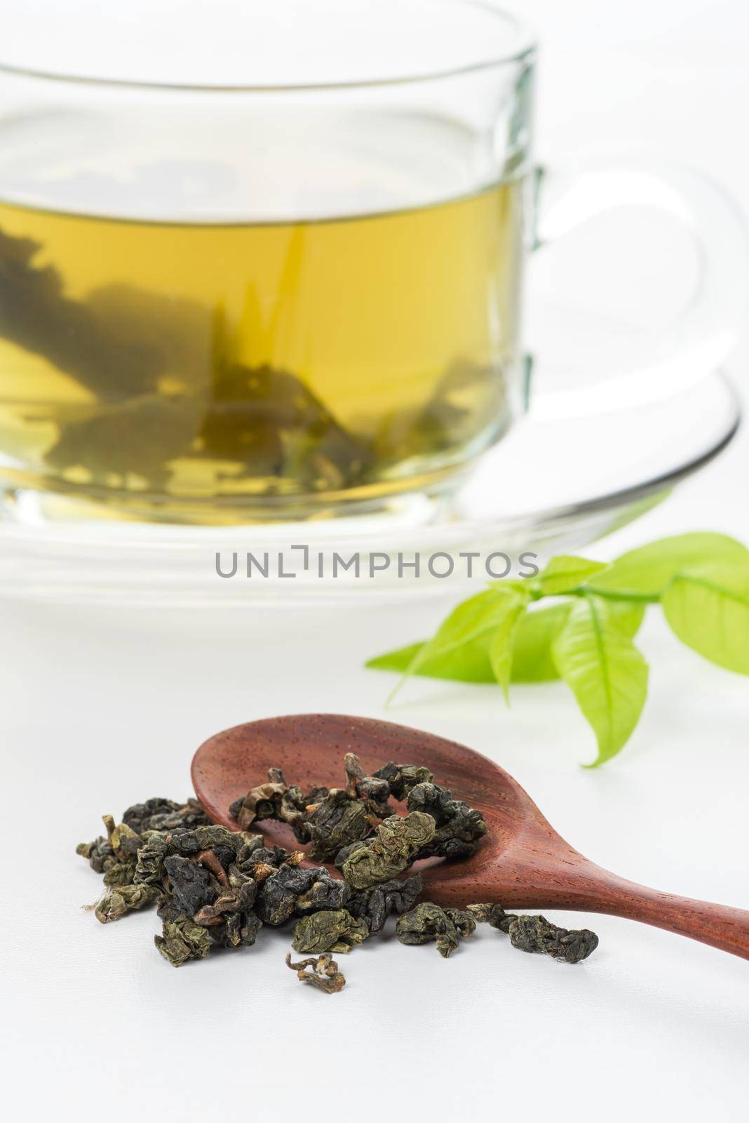 closeup dried green tea leaf with a cup of green tea