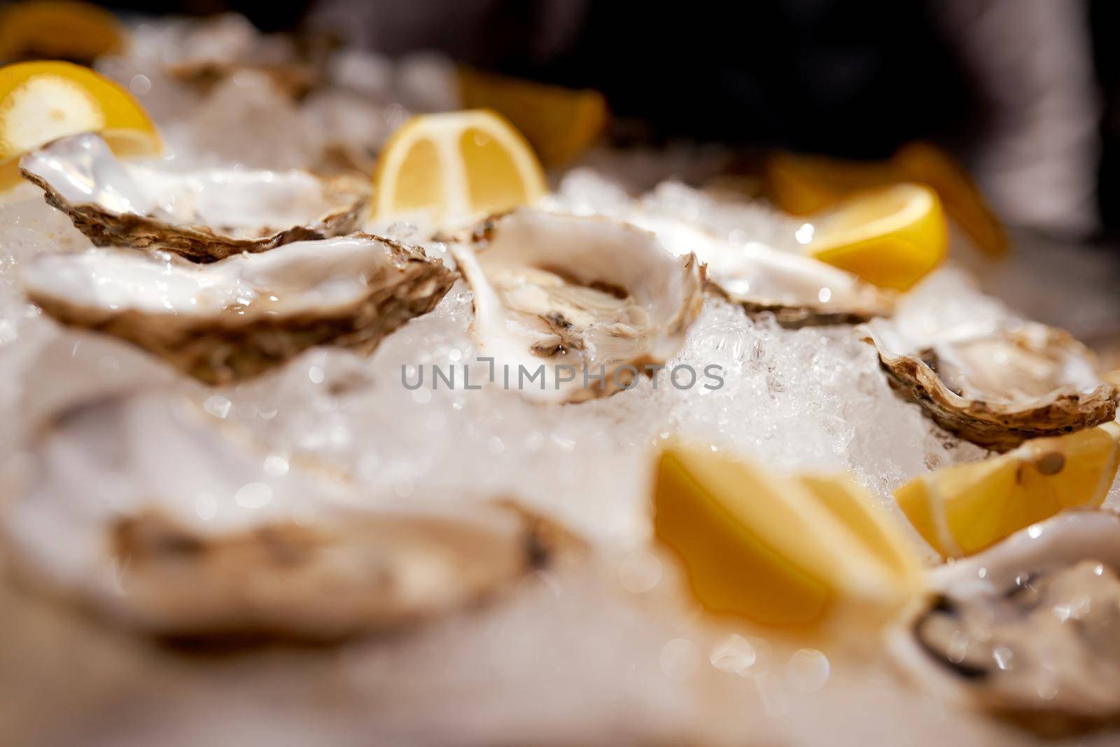 Cooled oysters refrigerated on ice with lemon by AntonIlchanka