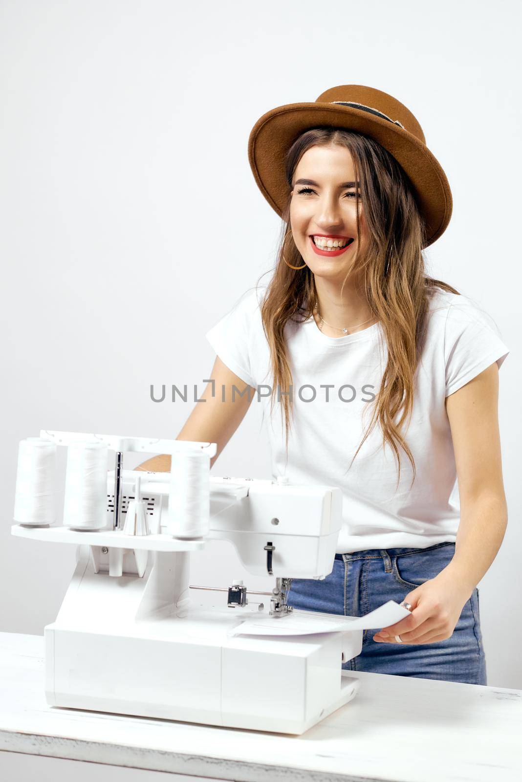 Smiling Girl with sewing machine poses for photo by AntonIlchanka