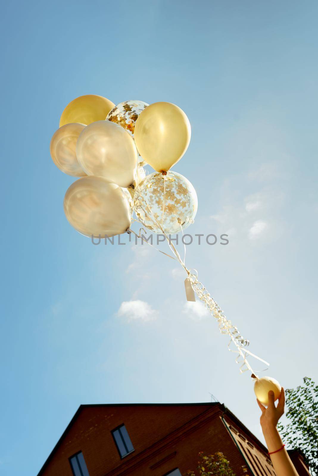 yellow white transparent balloons blue sky with children hands