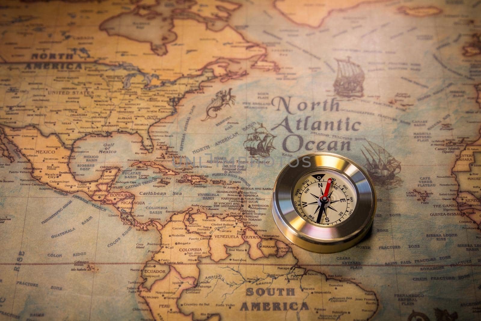 Old compass on vintage map. Adventure stories background. Retro style. The map used for background is in Public domain. Map source: Library of Congress. Country: Belgium Year: 1570. Author: Abraham Ortelius (1527-1598)