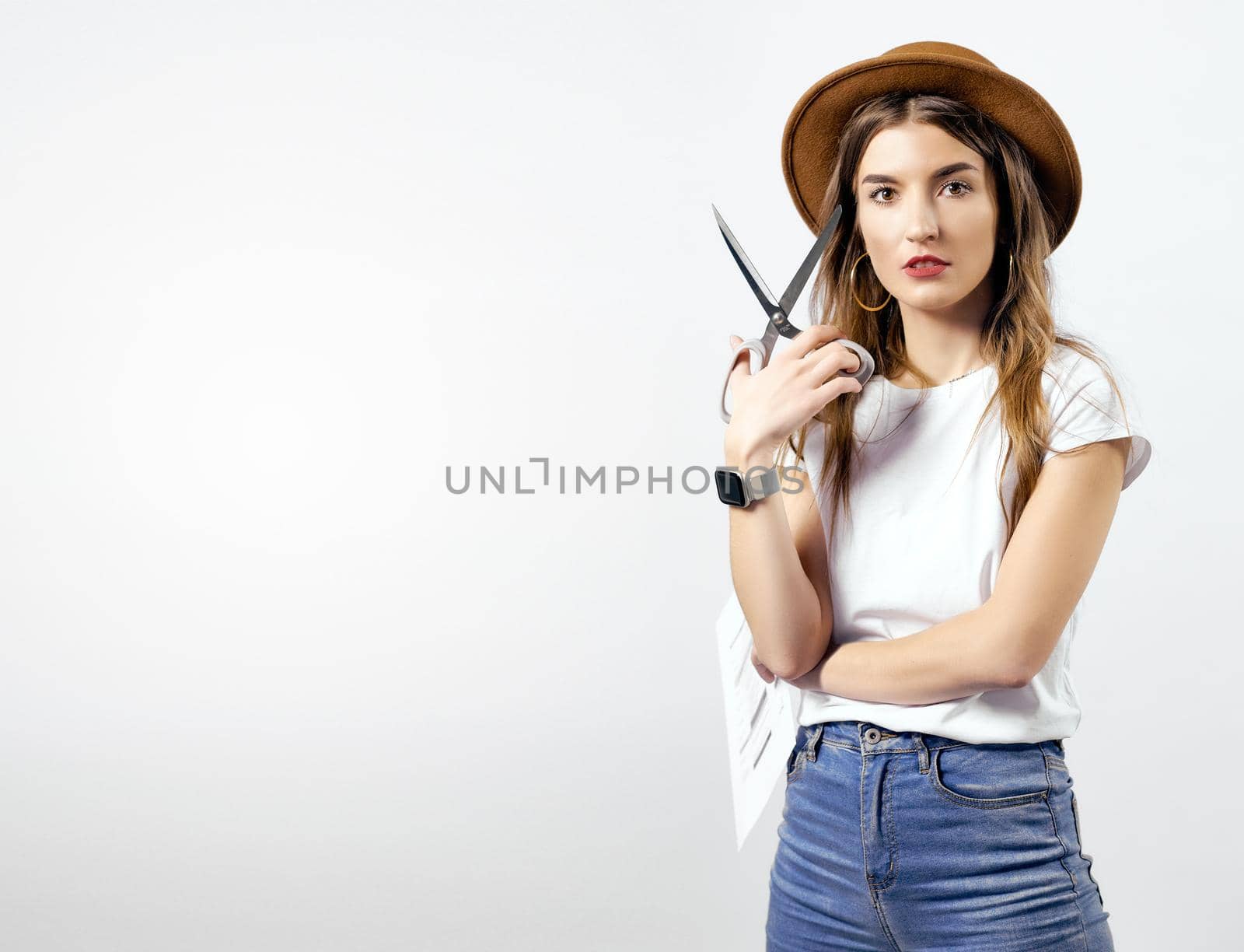 A woman wearing a hat looking through scissors hight quality 