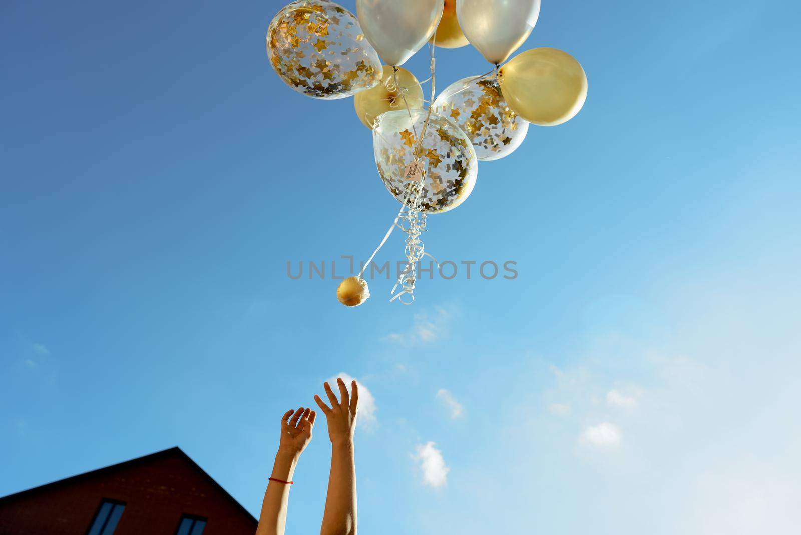 yellow white transparent balloons blue sky with children hands