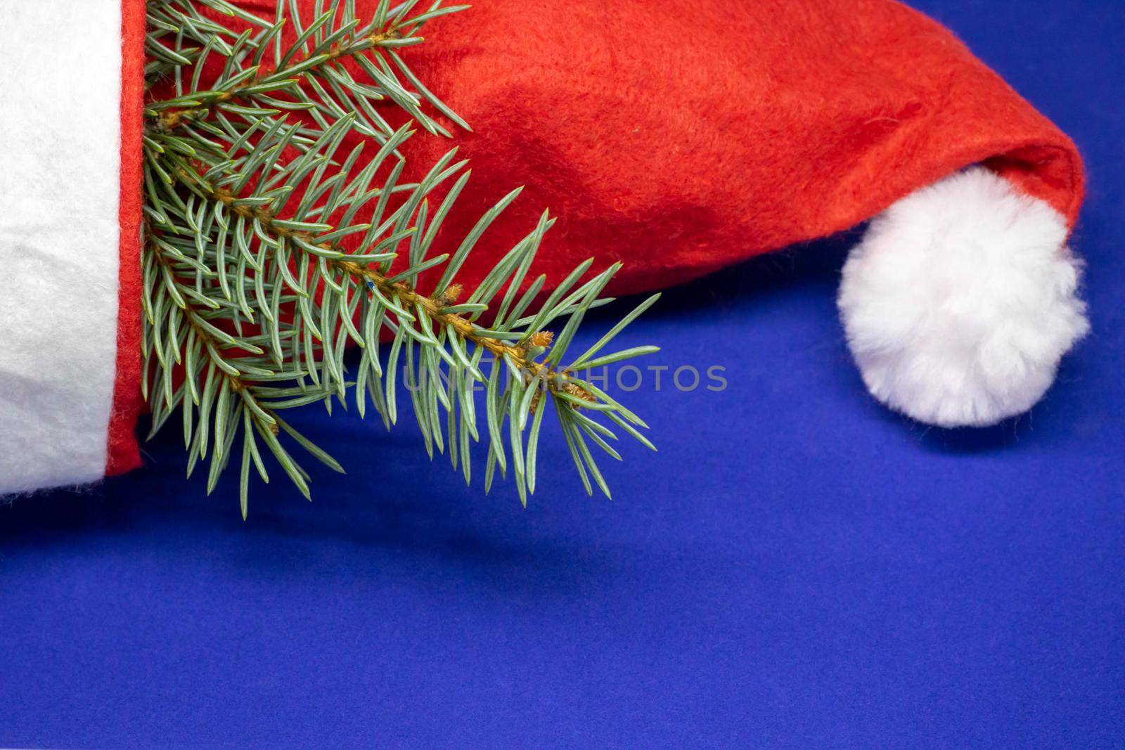 New year's red cap of Santa Claus. red white on blue background. blue 2020