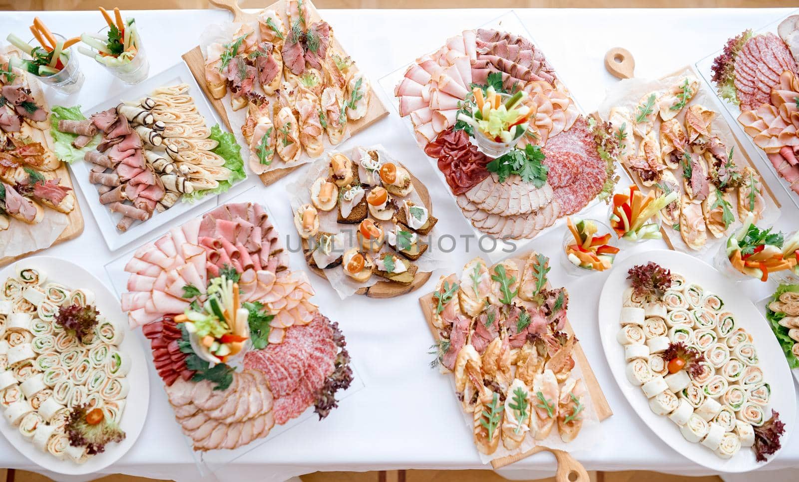 lots of meat snacks on a long white table on plates of trays. High quality photo