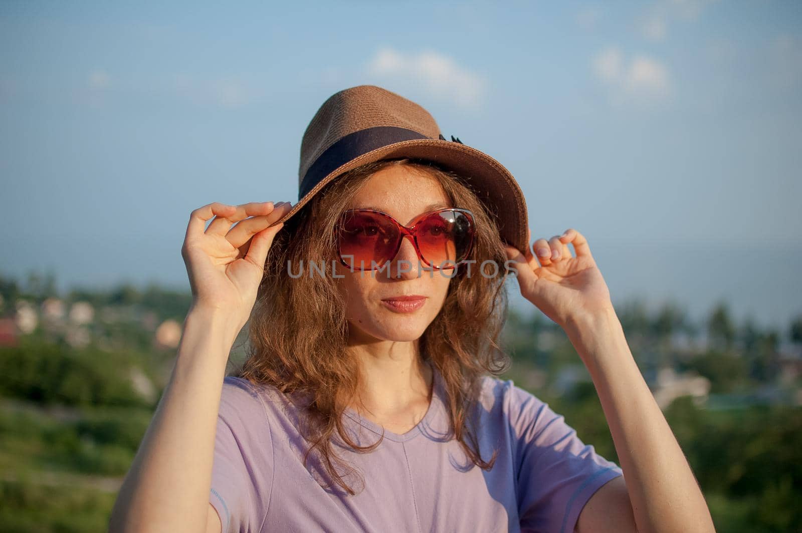 Young girl in dress is having great time during vacation in the summer on sky background in nature, travelling concept.