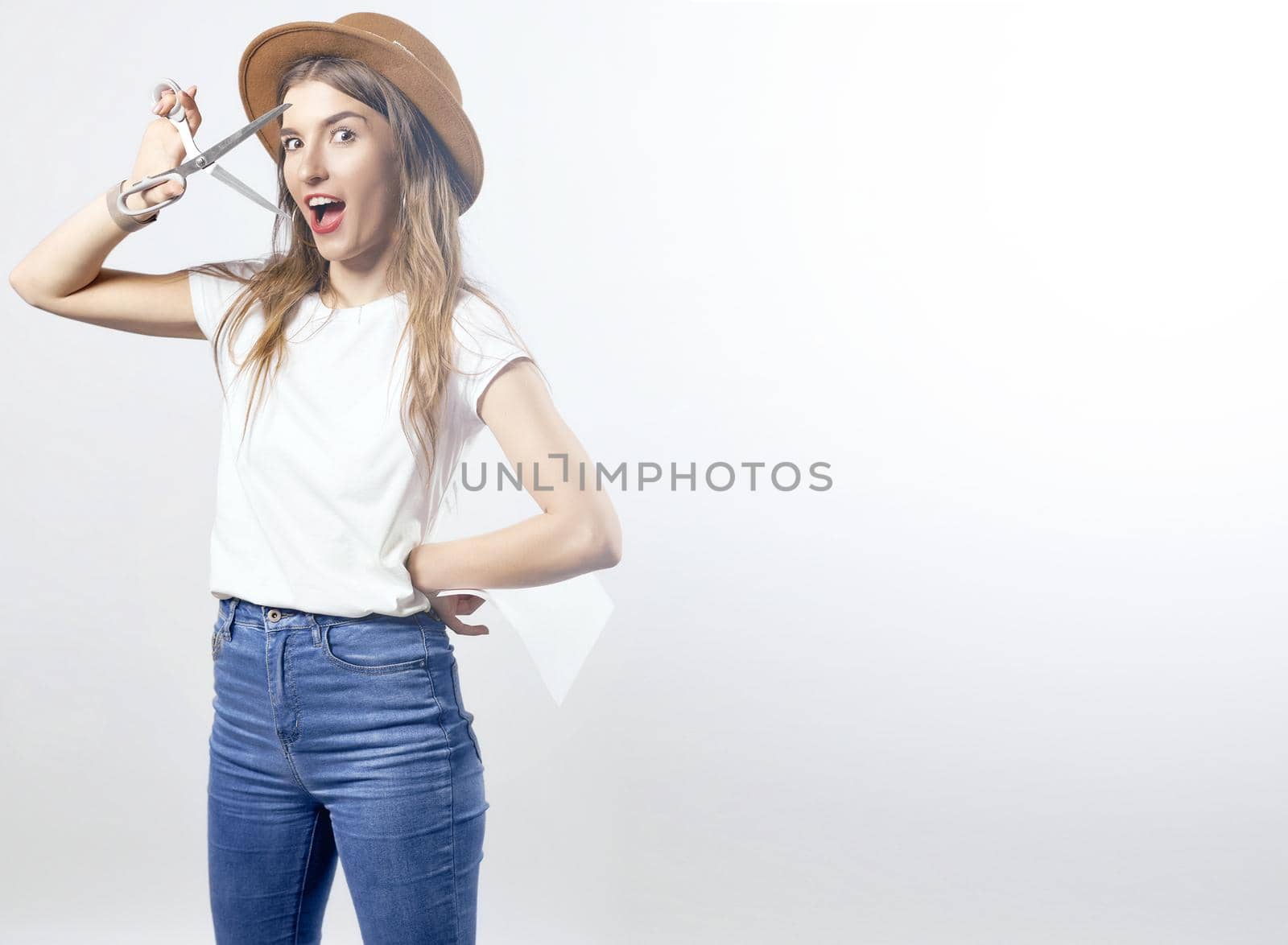 A woman wearing a hat looking through scissors hight quality 