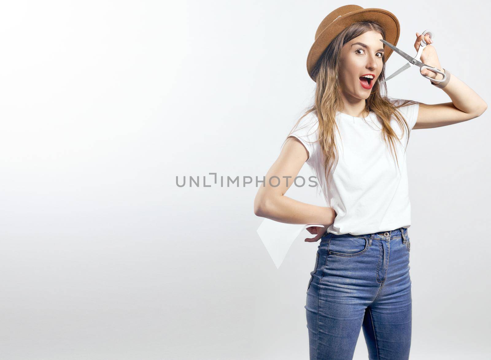 A woman wearing a hat looking through scissors hight quality 