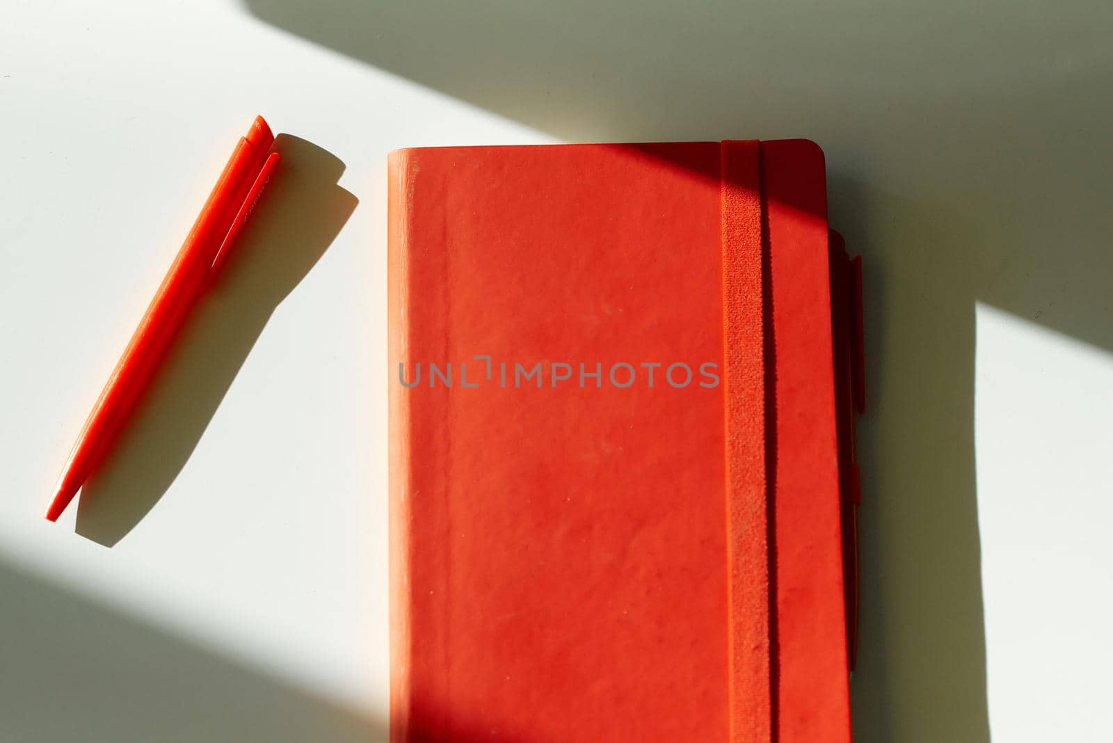 red notebook note pen sun light table