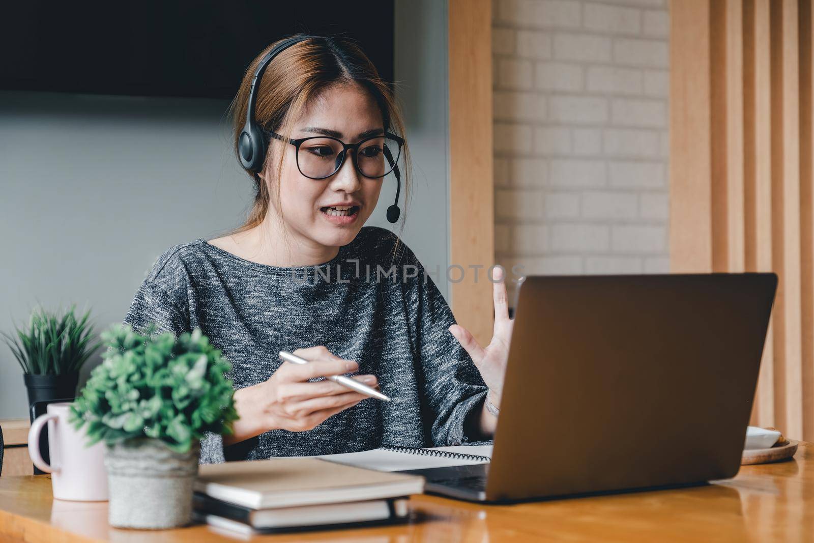 Asian woman wear headphones look at laptop enjoy study online with tutor, listen audio lecture watch webinar prepare for exams, e-learn, self education concept.